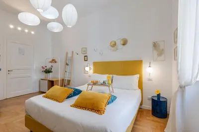 a bedroom with a large white bed with yellow pillows at Maison Vantaggio in Rome