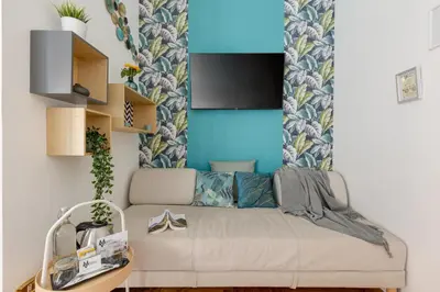 a living room with a couch and a blue wall at Maison Vantaggio in Rome