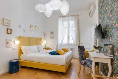 a bedroom with a bed and a desk and a television at Maison Vantaggio in Rome