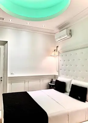 a bedroom with a white bed and a green ceiling at Tito Suite Guest House in Rome
