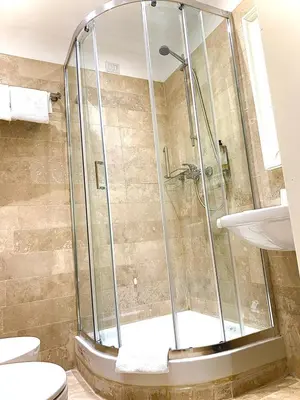 a shower in a bathroom with a toilet and a sink at Tito Suite Guest House in Rome