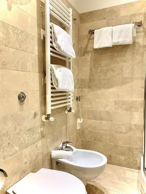 a bathroom with a toilet and a sink and towels at Tito Suite Guest House in Rome