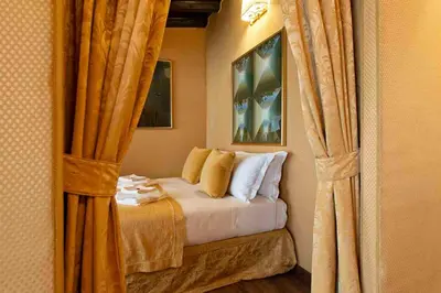 a bedroom with a bed with yellow curtains at Canova Rooms in Spanish Steps in Rome