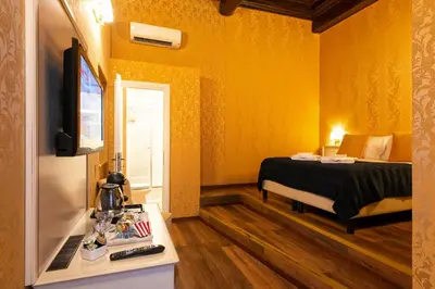 a small room with a bed and a television at Canova Rooms in Spanish Steps in Rome