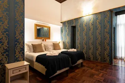 a bedroom with two beds with blue wallpaper at Canova Rooms in Spanish Steps in Rome