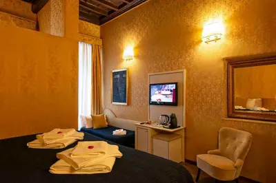a hotel room with two beds and a television at Canova Rooms in Spanish Steps in Rome