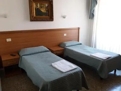 a room with two beds and a picture on the wall at Ritmo Blues Guest House in Rome