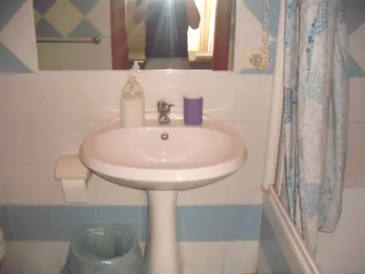 a sink in a bathroom with a person taking a picture at Ritmo Blues Guest House in Rome