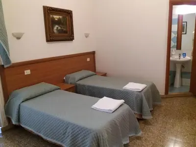 a room with two beds and a sink in it at Ritmo Blues Guest House in Rome