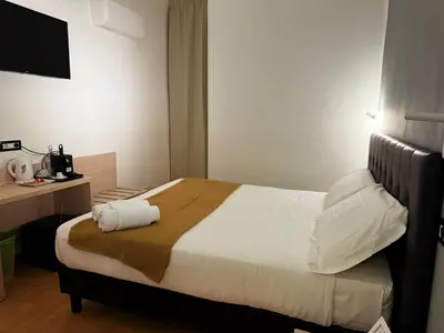 a bedroom with a bed and a desk with a television at Conte GuestHouse in Rome