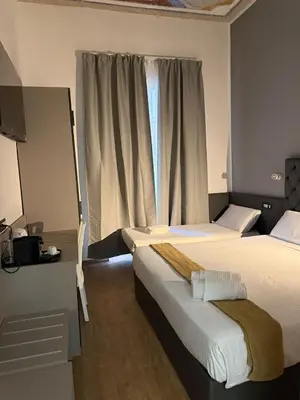 a hotel room with two beds and a window at Conte GuestHouse in Rome