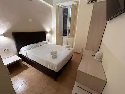 a small bedroom with a bed and a table at Conte GuestHouse in Rome