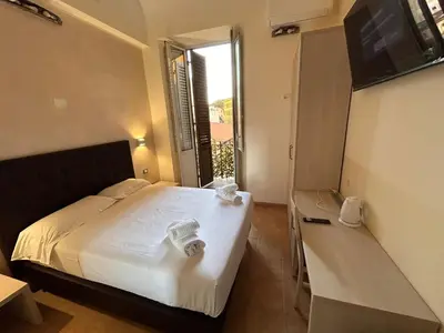 a bedroom with a bed and a tv and a window at Conte GuestHouse in Rome