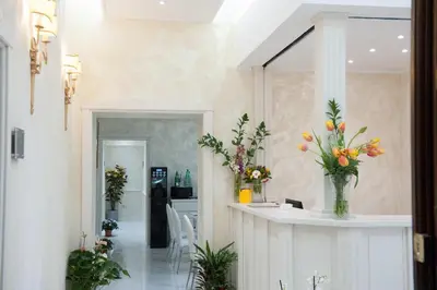 a lobby with a counter with flowers in a vase at Maison Tritone in Rome