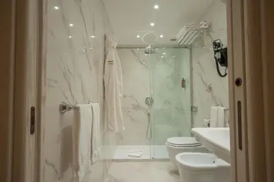 a bathroom with a shower and a toilet and a sink at Maison Tritone in Rome