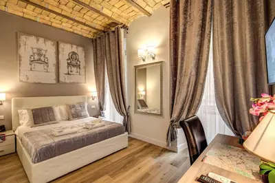 a bedroom with a bed and a table and a desk at Chester Suites in Rome