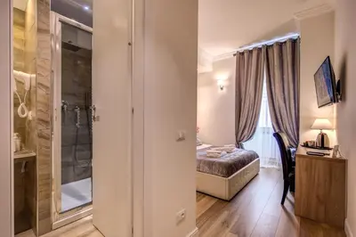 a bedroom with a bed and a glass shower at Chester Suites in Rome