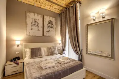 a bedroom with a bed with a large mirror at Chester Suites in Rome