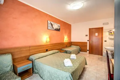 a hotel room with two beds and a sink at Hotel Millerose in Rome