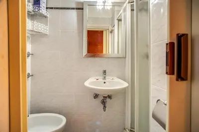 a bathroom with a sink and a toilet and a mirror at Hotel Millerose in Rome