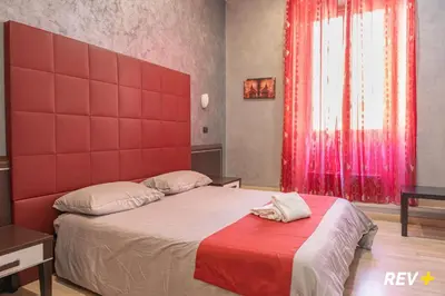 a bedroom with a large bed with a red headboard at New Inn in Rome