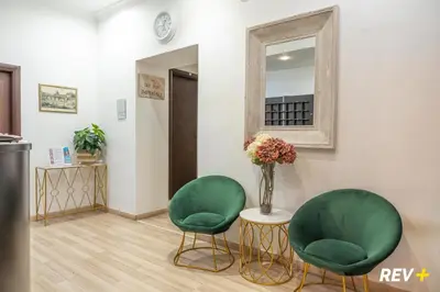 two green chairs and a table with a vase of flowers at New Inn in Rome