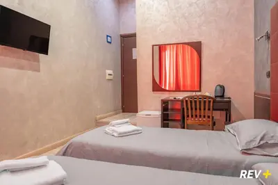 a bedroom with two beds and a desk and a chair at New Inn in Rome