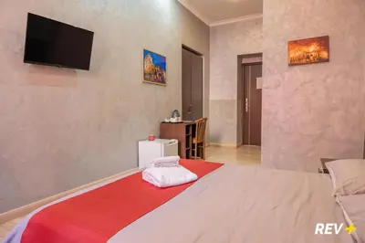 a bedroom with a bed with a television on the wall at New Inn in Rome