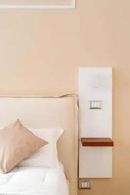 a bed with a pillow and a night stand next to it at CLAVDIA Flat in Rome