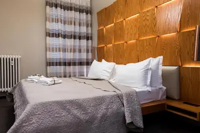 a hotel room with a bed with a wooden headboard at Unicum Vite in Rome