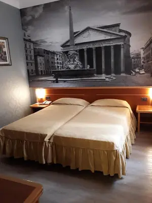 a bedroom with a large bed with a painting on the wall at Ele Green Park Hotel Pamphili in Rome