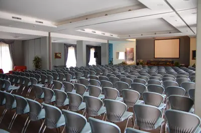 an empty lecture hall with chairs and a screen at Ele Green Park Hotel Pamphili in Rome