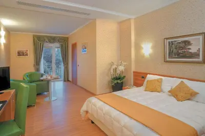a hotel room with a bed and a television at Ele Green Park Hotel Pamphili in Rome