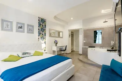 a bedroom with a bed and a tub and a sink at Aeterna Rooms Collection GuestHouse in Rome