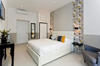 a white bedroom with a white bed and a desk at Aeterna Rooms Collection GuestHouse in Rome