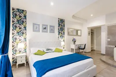 a bedroom with a large white bed and a desk at Aeterna Rooms Collection GuestHouse in Rome