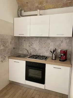 a kitchen with white cabinets and a stove top oven at Campani Luxury Flat in Rome