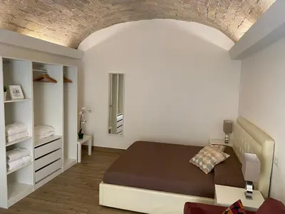 a white bedroom with a bed and a mirror at Campani Luxury Flat in Rome