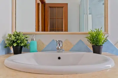 a white sink in a bathroom with two potted plants at DaliTourism - Vatican Apartment 9 in Rome