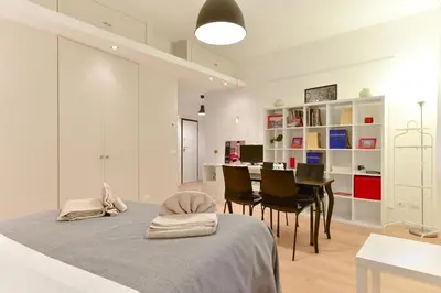 a bedroom with a bed and a table and chairs at iFlat Via Veneto Design Studio in Rome