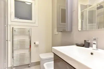 a bathroom with a sink and a toilet and a mirror at iFlat Via Veneto Design Studio in Rome