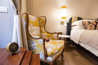 a bedroom with a chair next to a bed at Casa Fabbrini Fancy Suites in Rome