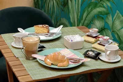 a table with plates of food and cups of coffee at Roma Suite Monti in Rome