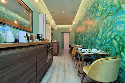 a restaurant with tables and chairs and a mural at Roma Suite Monti in Rome