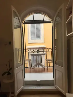 an open door to a balcony with a table and chairs at Rome dreaming house in Rome