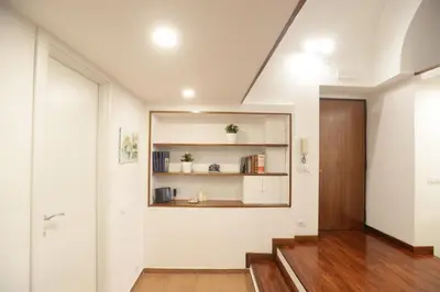 a hallway with white walls and a wooden door at Home Alex in Rome