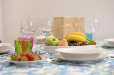 a table with two wine glasses and a plate of fruit at Home Alex in Rome