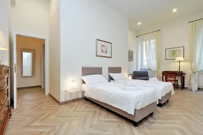a bedroom with a large bed and a chair in it at Sistina 2 in Rome