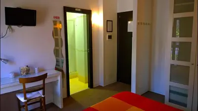 a room with a bed and a chair and a mirror at Almi Rooms in Rome