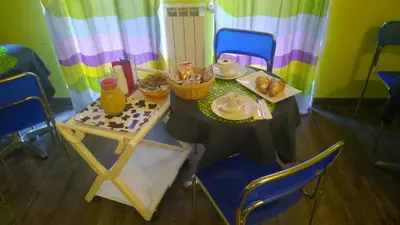 a small table with chairs and a table with food on it at Almi Rooms in Rome